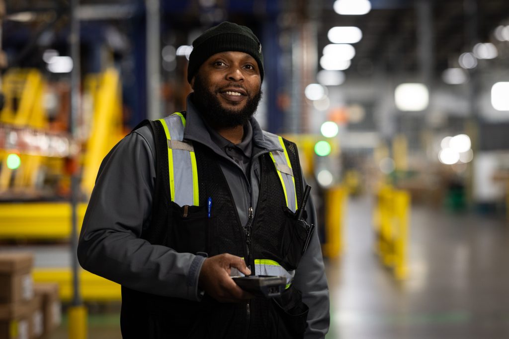 A smiling CLI employee using a scan gun